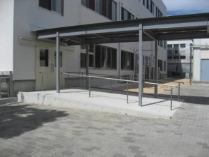 3階建ての仮設校舎の外観2。渡り廊下。校舎の出入口から緩やかなスロープが渡り廊下に続いている様子。