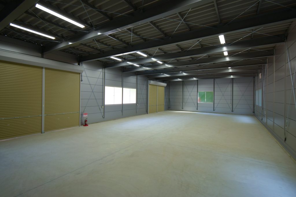 事務所兼倉庫の内観1。4.5mの高い梁高で広々とした空間が確保されている様子。