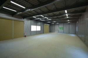 事務所兼倉庫の内観1。4.5mの高い梁高で広々とした空間が確保されている様子。