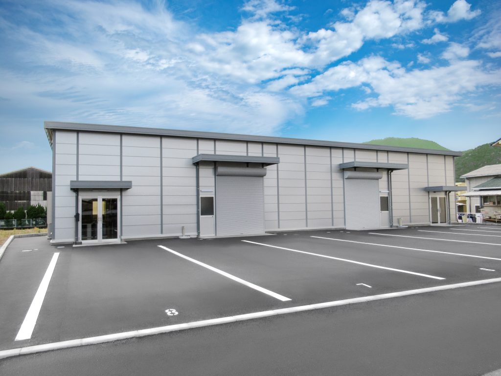 事務所兼倉庫の外観2。正面左側から。駐車場に面した2か所の開口部が特徴的。