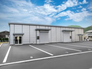 事務所兼倉庫の外観2。正面左側から。駐車場に面した2か所の開口部が特徴的。