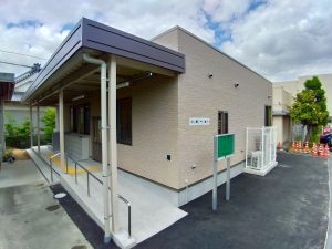 児童クラブの外観2。左斜めから。スロープの先には玄関の出入り口があり、下駄箱が配置されている。