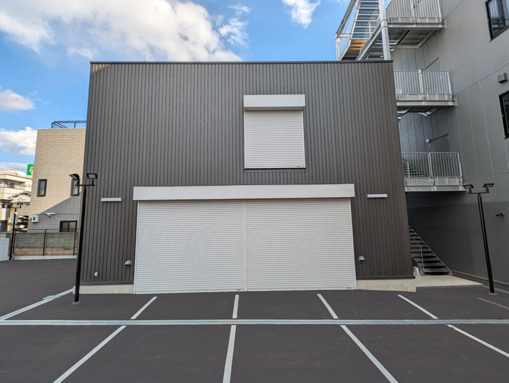 2階建て倉庫の外観1。正面から、1階と2階に設けられた軽量電動シャッターが写っている。