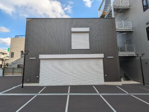 2階建て倉庫の外観1。正面から、1階と2階に設けられた軽量電動シャッターが写っている。