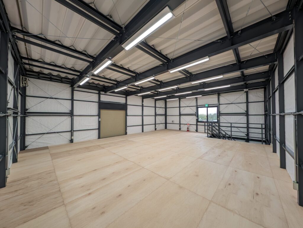 2階の内観。室内の奥から見た階段と軽量電動シャッター。