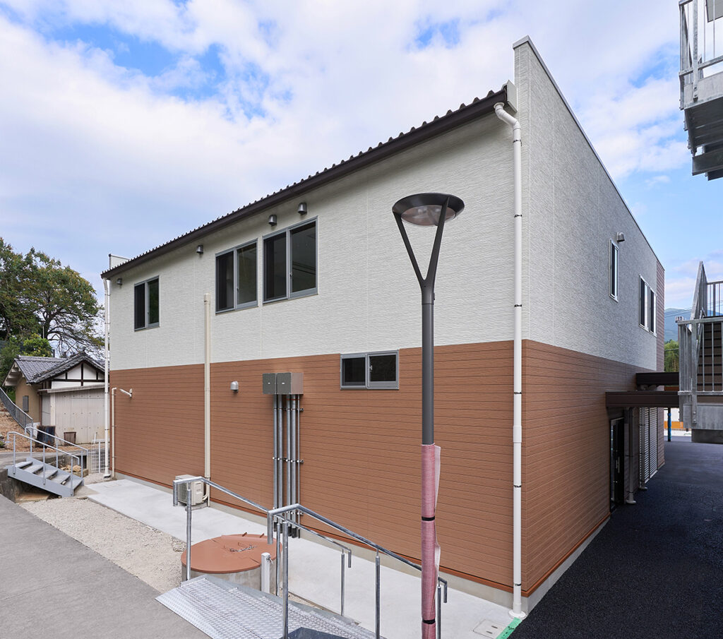 2階建て倉庫兼事務所の外観裏手。右斜めから見た建物の裏手と外階段。