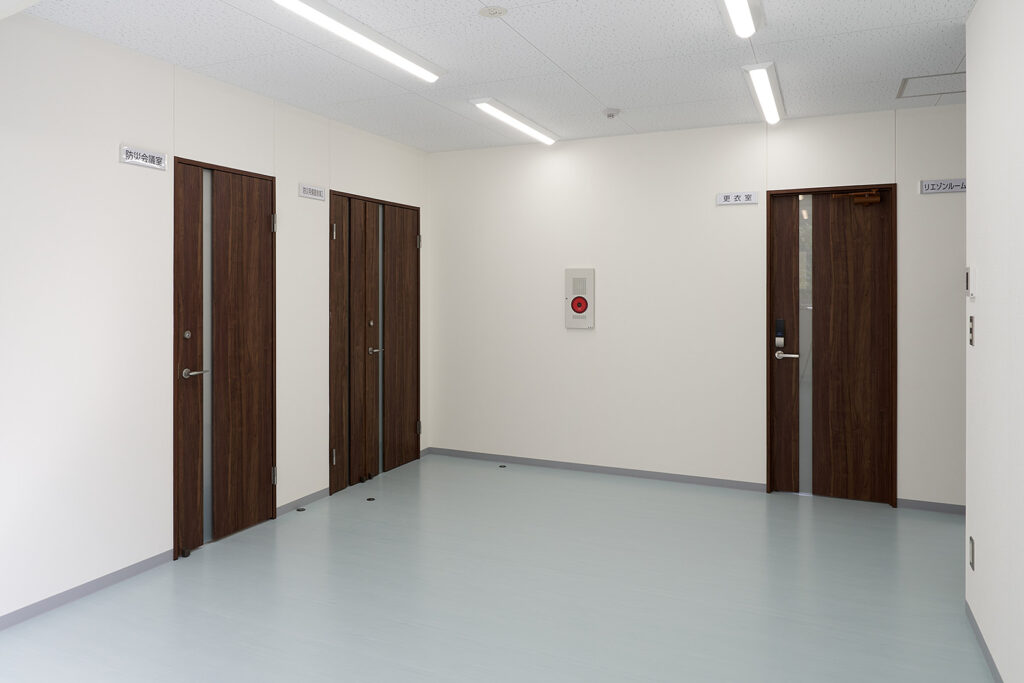 2階建て倉庫兼事務所の2階ホール内観。会議室、倉庫、更衣室へ続くドア。