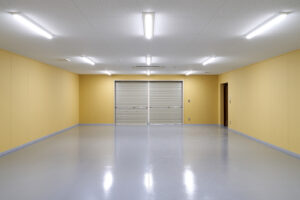 防災倉庫の室内から写した軽量手動シャッターとドア。