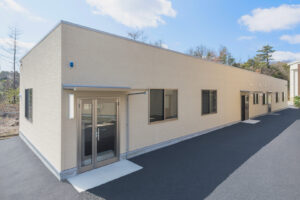 1階建て倉庫兼事務所の外観。左斜めから写した庇のある事務所玄関。