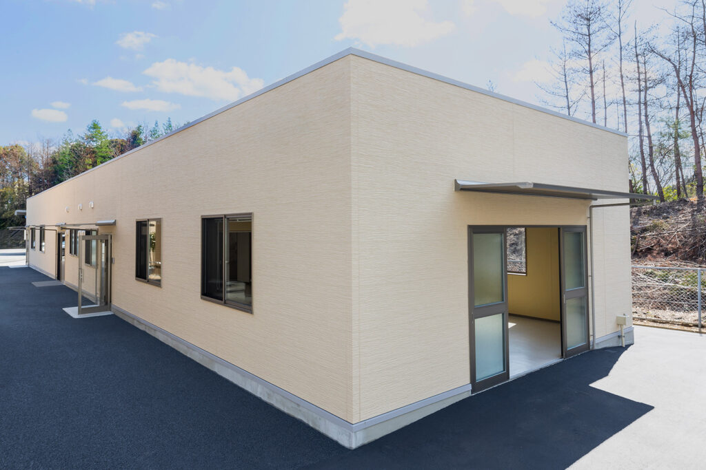 1階建て倉庫兼事務所の外観。右斜めから写した倉庫出入り口の庇付4枚引き戸。