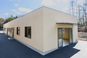 1階建て倉庫兼事務所の外観。右斜めから写した倉庫出入り口の庇付4枚引き戸。