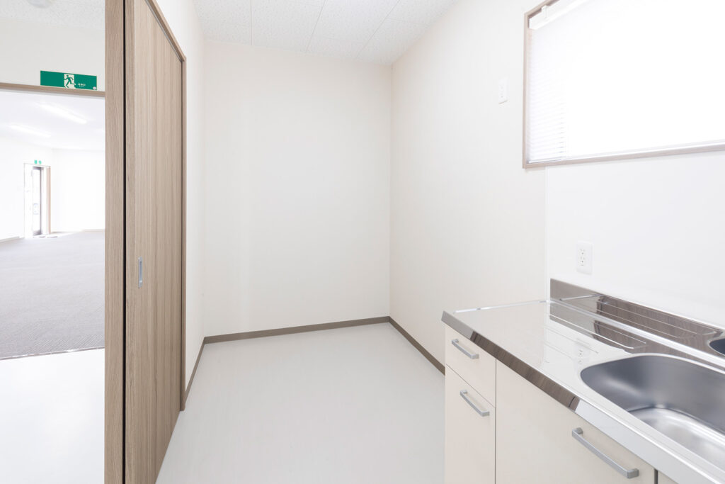 1階建て倉庫兼事務所の内観。給湯室の出入り口から写した流し台と室内。