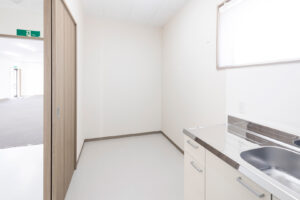 1階建て倉庫兼事務所の内観。給湯室の出入り口から写した流し台と室内。